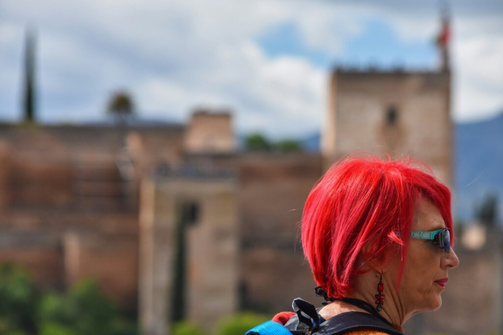 red hair woman in front of la alhambra in granada